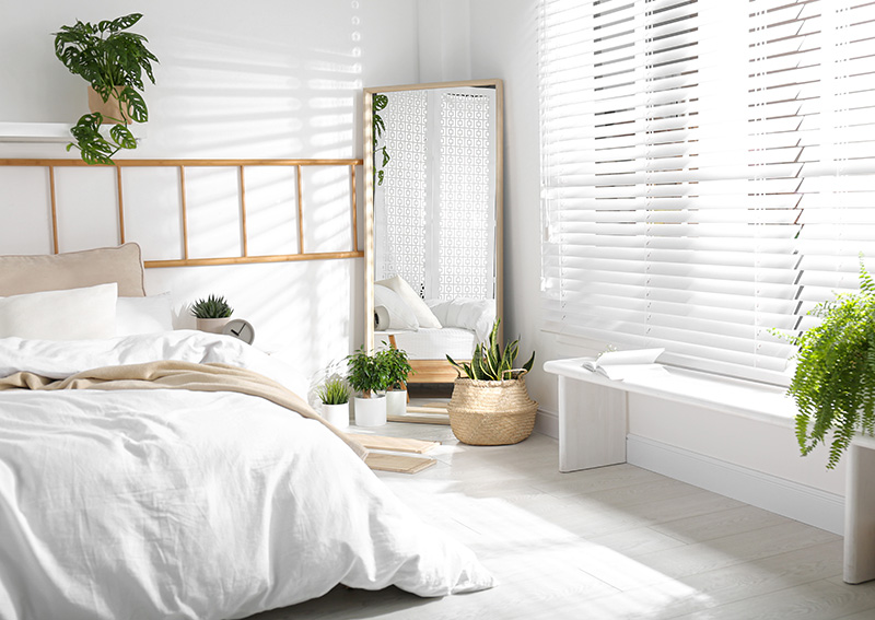 Lustra oprawione w ramy z drewna podkreślają przytulną atmosferę w sypialni